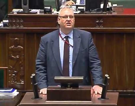 Bogdan Roman Święczkowski, prawnik i autor, przedstawiony w naturalnej pozie, być może z jedną ze swoich książek, ukazujący jego osobistą stronę i determinację.