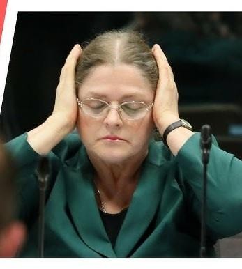 Krystyna Pawłowicz w otoczeniu książek prawniczych, symbolizującym jej wykształcenie i karierę naukową.