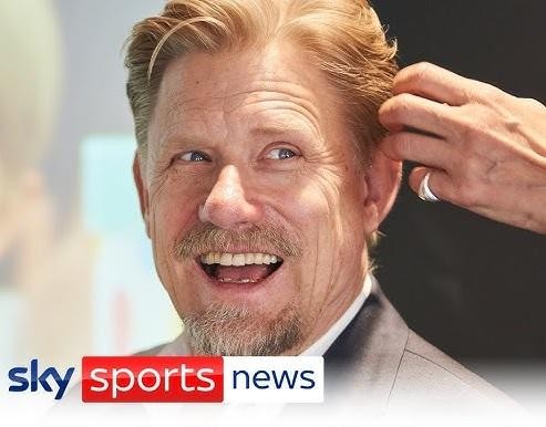 Peter Schmeichel w akcji, wykonujący efektowną paradę bramkarską na stadionie Old Trafford, w koszulce Manchesteru United.
