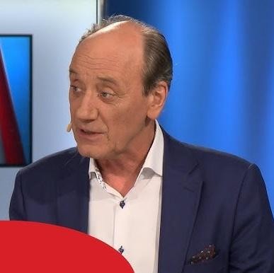Stary mikrofon radiowy z rozmytym tłem stadionu sportowego, symbolizujący początki kariery komentatora.