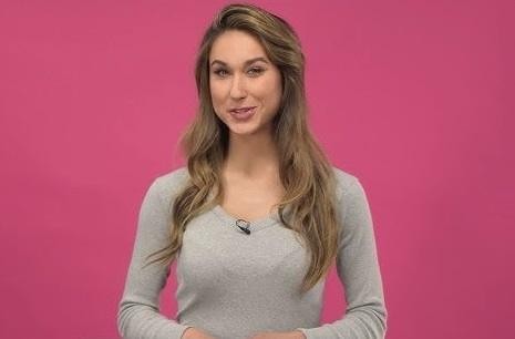 Ida Nowakowska uśmiecha się, trzymając telefon z widocznym profilem Instagram, w tle rozmyte studio.