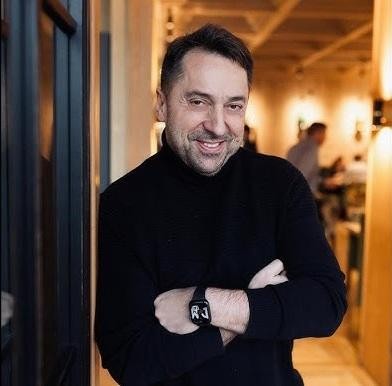 Marcin Miller w trakcie występu telewizyjnego, uśmiechnięty i charyzmatyczny.