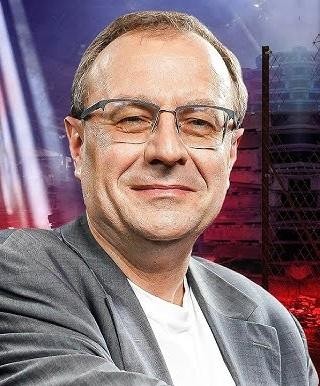 Antoni Dudek podczas wykładu lub prezentacji, dynamicznie opowiadający o historii lub polityce.