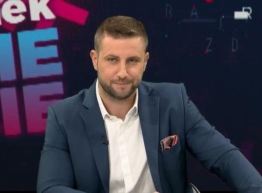 Miłosz Kłeczek podczas dynamicznej debaty w studiu telewizyjnym, gestykulujący i wyrażający swoje stanowisko.